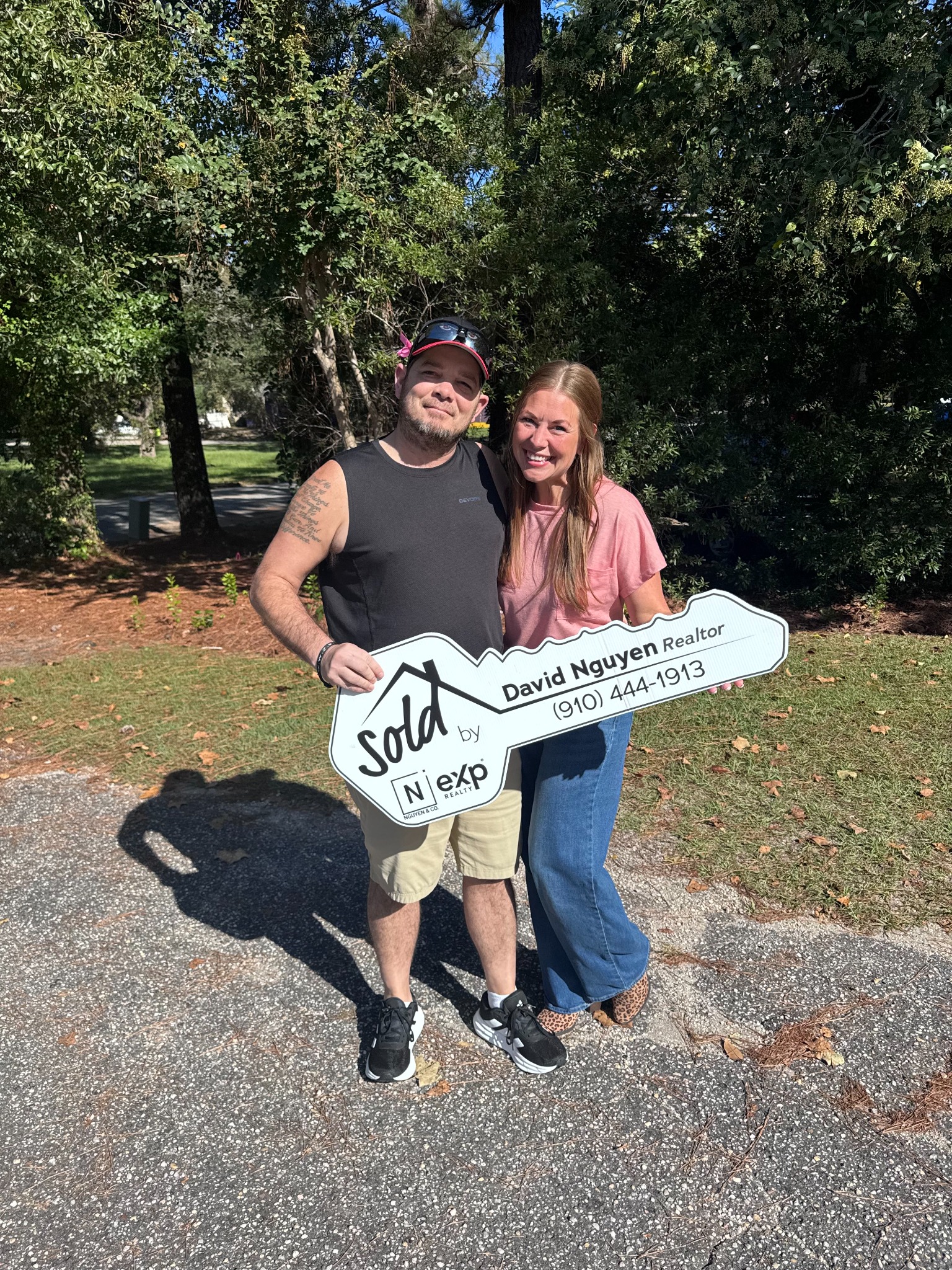 Happy homeowners holding their sold key